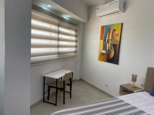 a bedroom with a bed and a table and a painting at Studio Très Moderne Gallo 1 - Mamelles Dakar in Dakar