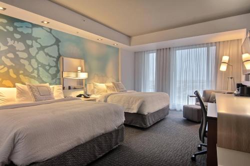 a hotel room with two beds and a large window at Courtyard by Marriott Quebec City in Quebec City