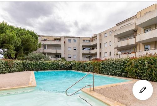 une piscine en face d'un grand bâtiment dans l'établissement Superbe Appartement t3 avec piscine, à Montpellier