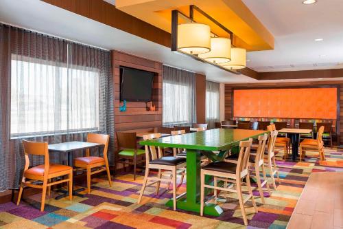 a dining room with tables and chairs and a flat screen tv at Fairfield Inn & Suites Mansfield Ontario in Mansfield