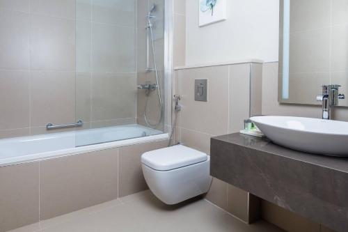 a bathroom with a toilet and a sink and a bath tub at Residence Inn by Marriott Algiers Bab Ezzouar in Alger