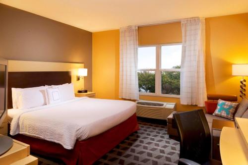 ein Hotelzimmer mit einem Bett und einem Fenster in der Unterkunft TownePlace Suites by Marriott Jacksonville in Jacksonville