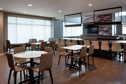 a dining room with tables and chairs and windows at Residence Inn by Marriott Lancaster in Lancaster