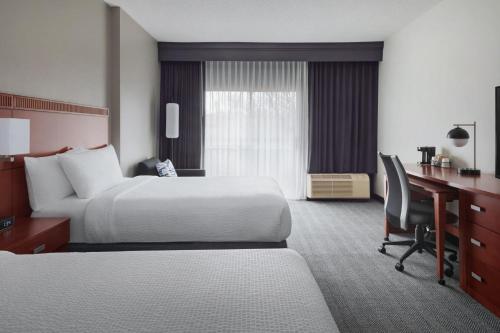 Pokój hotelowy z łóżkiem i biurkiem w obiekcie Courtyard by Marriott New Carrollton Landover w mieście Landover