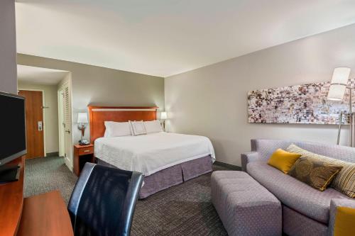 um quarto de hotel com uma cama e um sofá em Courtyard Fort Myers at I-75 and Gulf Coast Town Center em Estero