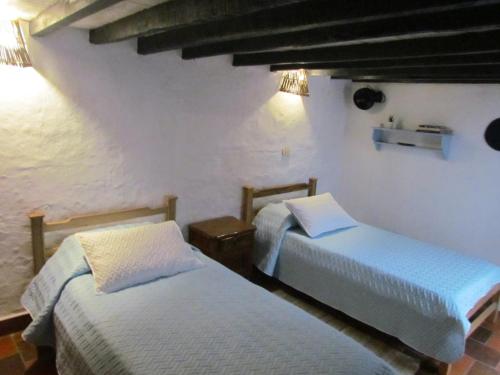 a room with two beds in a room at Casa Yerbabuena- Rustiko in Barichara