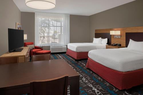 a hotel room with two beds and a desk at TownePlace Suites by Marriott Big Spring in Big Spring