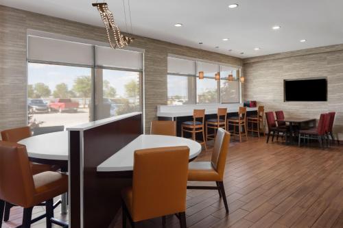 a restaurant with tables and chairs and a flat screen tv at TownePlace Suites by Marriott Big Spring in Big Spring
