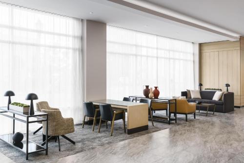a living room with a table and chairs at AC Hotel By Marriott Raleigh Downtown in Raleigh
