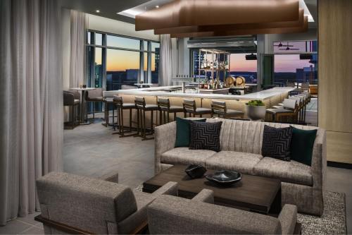 a living room with a bar and a restaurant at AC Hotel By Marriott Raleigh Downtown in Raleigh