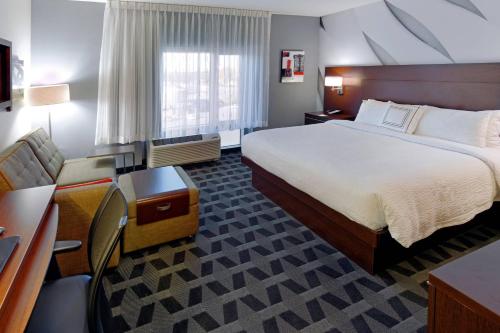 ein Hotelzimmer mit einem großen Bett und einem Schreibtisch in der Unterkunft TownePlace Suites by Marriott Springfield in Springfield