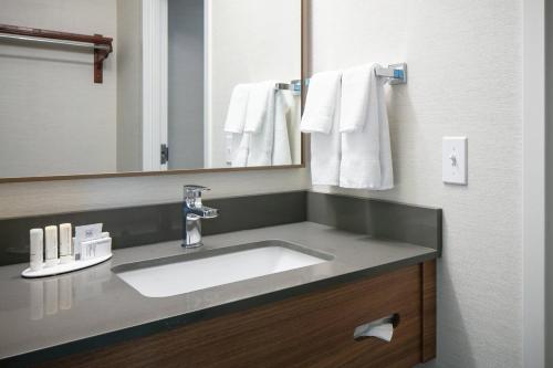 a bathroom with a sink and a mirror and towels at Fairfield Inn & Suites by Marriott Tulsa Central in Tulsa