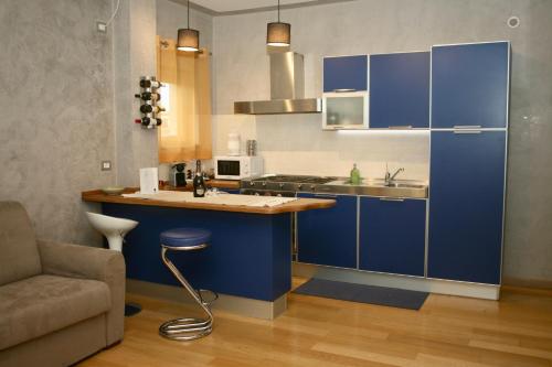 een keuken met blauwe kasten, een wastafel en een bank bij Appartamento Deluxe Valadier in Spoleto