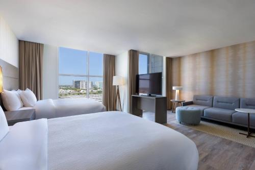 メリダにあるResidence Inn by Marriott Meridaのベッド1台、薄型テレビが備わるホテルルームです。