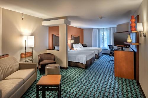 Fairfield Inn & Suites by Marriott New Braunfels في نيو بروانفيلز: غرفة فندقية بسريرين واريكة