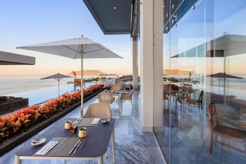 a restaurant with tables and chairs and a view of the ocean at Courtyard by Marriott Mazatlan Beach Resort in Mazatlán