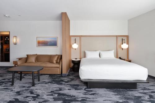 a hotel room with a bed and a couch at Fairfield by Marriott Inn & Suites San Francisco Pacifica in Pacifica