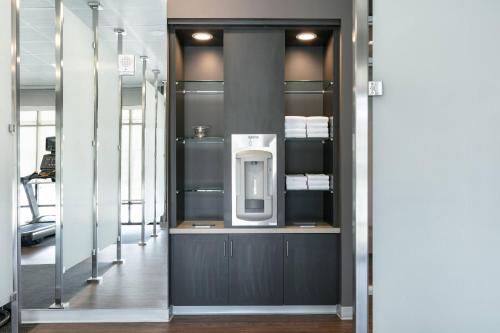 a bathroom with a white soap dispenser on a wall at Courtyard Sioux City Downtown/Convention Center in Sioux City