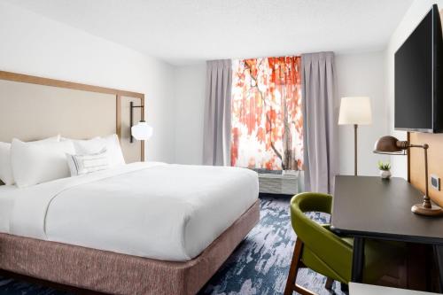 a hotel room with a large bed and a desk at Fairfield Inn by Marriott Joliet South in Joliet