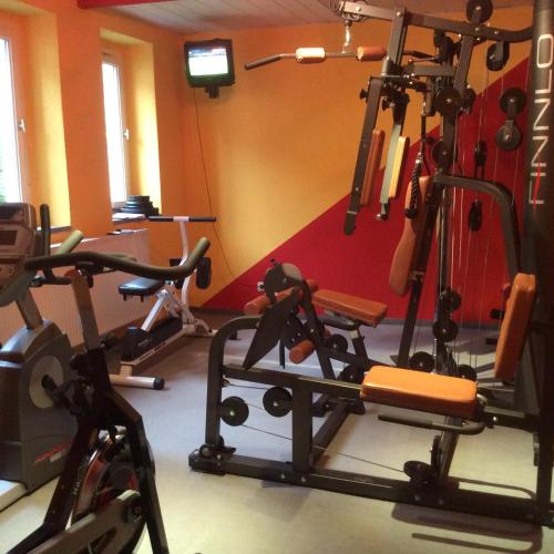 a gym with several exercise bikes in a room at Landhotel Flöhatal in Heidersdorf
