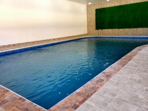 - une piscine dans une maison d'eau bleue dans l'établissement DURAZNO INN, à Nuevo Casas Grandes