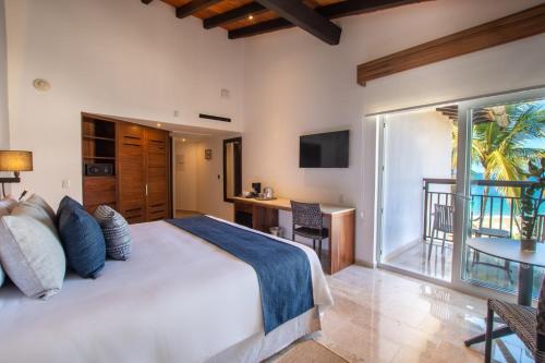 Buenaventura Grand Hotel & Great Moments - All Inclusive في بويرتو فايارتا: غرفة نوم بسرير كبير وبلكونة