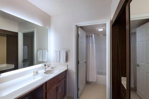 a bathroom with a sink and a mirror and a shower at Residence Inn by Marriott Austin The Domain Area in Austin