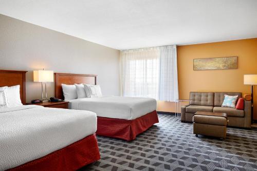 um quarto de hotel com duas camas e uma cadeira em TownePlace Suites by Marriott Midland em Midland