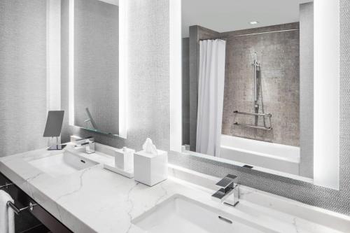 a white bathroom with a sink and a shower at Envue, Autograph Collection in Weehawken