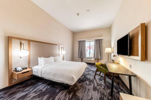 a hotel room with a bed and a desk and a television at Fairfield Inn & Suites by Marriott Gainesville I-35 in Gainesville