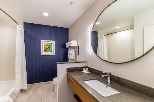 根茲維的住宿－Fairfield Inn & Suites by Marriott Gainesville I-35，一间带水槽和镜子的浴室