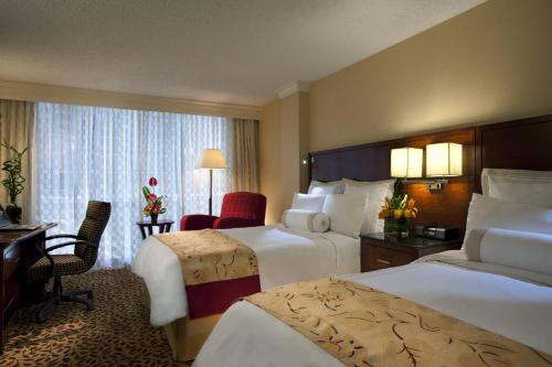 a hotel room with two beds and a desk at Houston Marriott West Loop by The Galleria in Houston