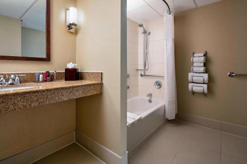 uma casa de banho com uma banheira, um lavatório e um chuveiro em Houston Marriott West Loop by The Galleria em Houston