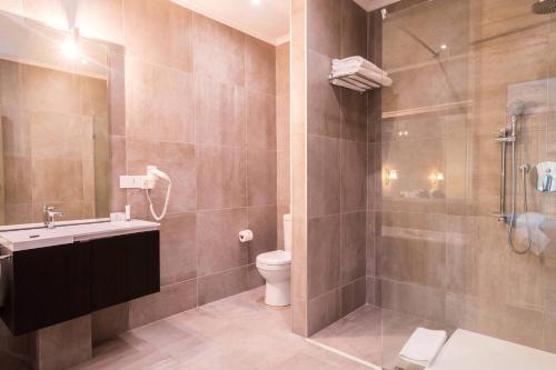 a bathroom with a toilet and a sink and a shower at Protea Hotel by Marriott Gaborone Masa Square in Gaborone