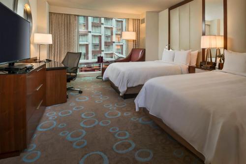 a hotel room with two beds and a flat screen tv at Marriott Marquis Washington, DC in Washington