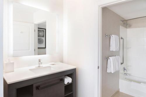 a white bathroom with a sink and a mirror at Residence Inn by Marriott Sacramento Downtown at Capitol Park in Sacramento