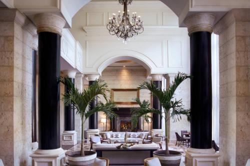 un gran vestíbulo con columnas y una lámpara de araña en The Ritz-Carlton Coconut Grove, Miami en Miami