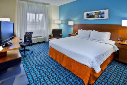 um quarto de hotel com uma cama, uma secretária e uma televisão em Fairfield Inn Owensboro em Owensboro