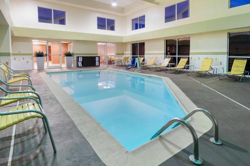 a large swimming pool in a building with chairs at Fairfield Inn Owensboro in Owensboro