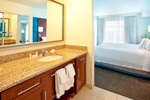 baño con lavabo, cama y espejo en Residence Inn by Marriott Portland Airport at Cascade Station en Portland