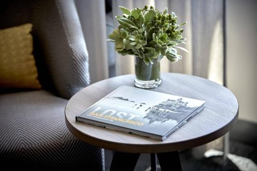 a table with a book and a vase of flowers on it at San Francisco Marriott Fisherman's Wharf in San Francisco