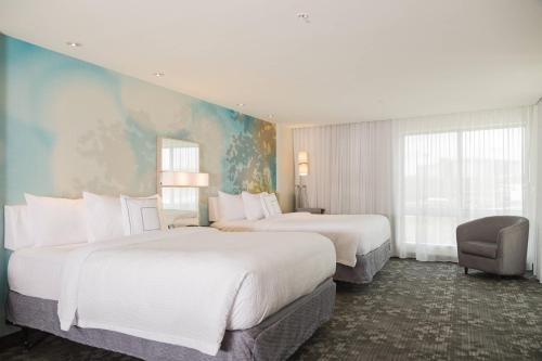 um quarto de hotel com duas camas e uma cadeira em Courtyard by Marriott Morgantown em Morgantown