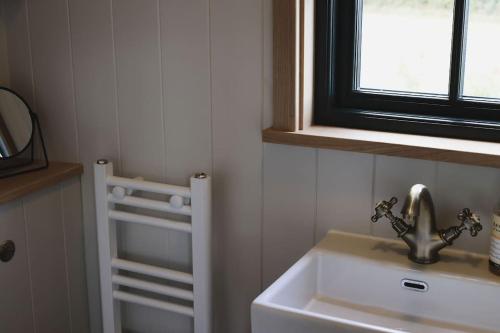 uma casa de banho com um lavatório e uma janela em The Winford Retreat em Winford