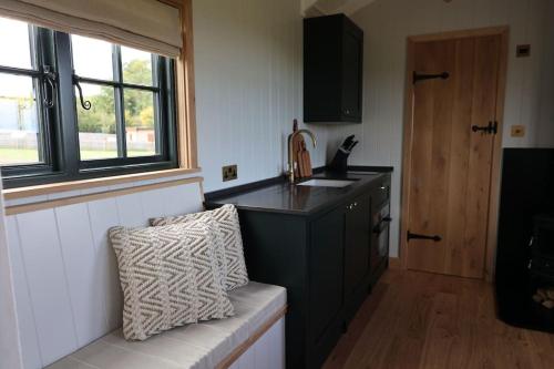 uma cozinha com um balcão preto e uma janela em The Winford Retreat em Winford