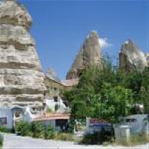 a stone building with a tree in front of it at Anatolia cave hotel Pension in Goreme
