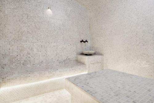 a white bathroom with a tub and a sink at Courtyard by Marriott World Trade Centre, Dubai in Dubai