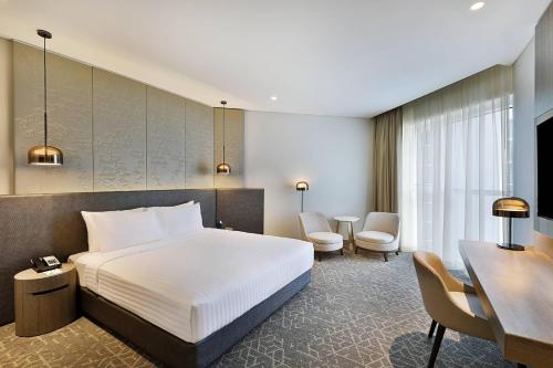 a hotel room with a bed and a desk at Courtyard by Marriott Dubai, Al Barsha in Dubai
