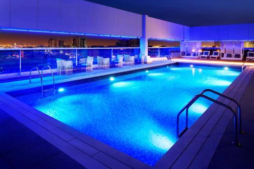 a large swimming pool in a hotel at night at Courtyard by Marriott Dubai, Al Barsha in Dubai