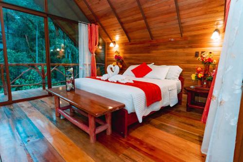a bedroom with a bed and a table in a room at Suchipakari Amazon Eco -Lodge & Jungle Reserve in Puerto Misahuallí
