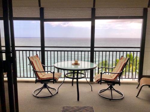 a balcony with a table and chairs and the ocean at AMAZING OCEAN VIEW - Kona Alii Condo KA606 in Kailua-Kona